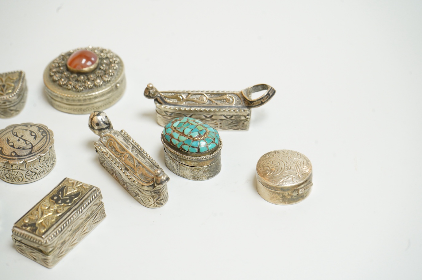 A collection of assorted pill boxes including one modern circular silver, a Mexican 925, six continental white metal, one inset with chalcedony and two with niello decoration and three other unmarked white metal pill box